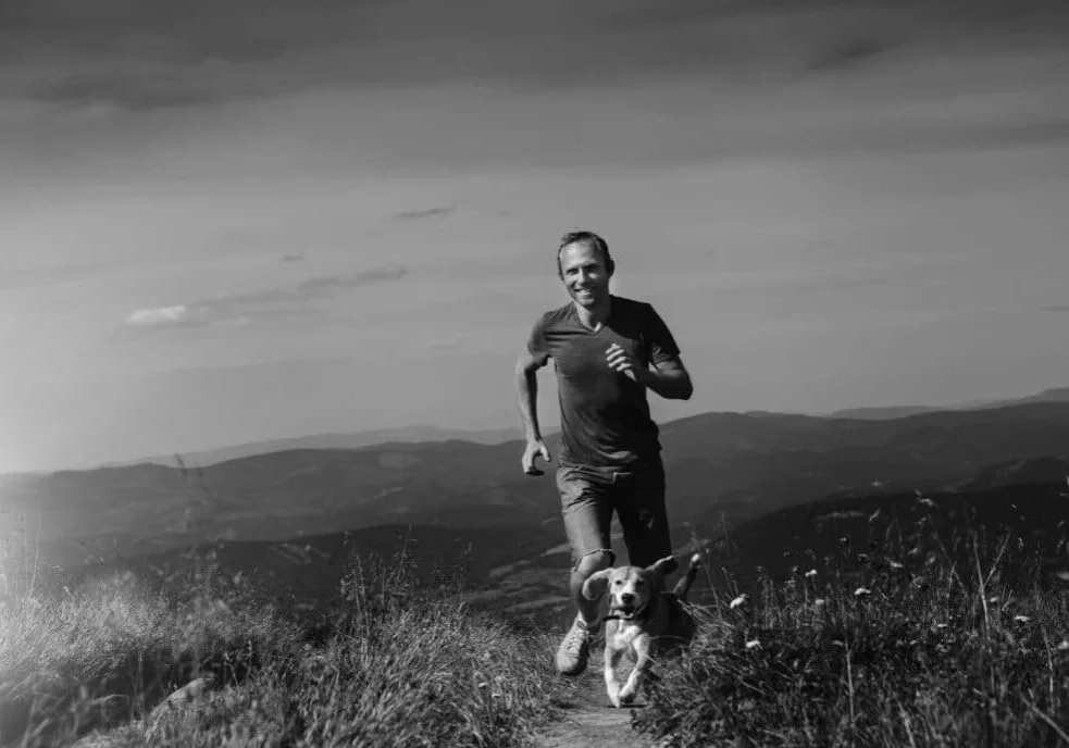 Man running with his dog on the mountain tableland